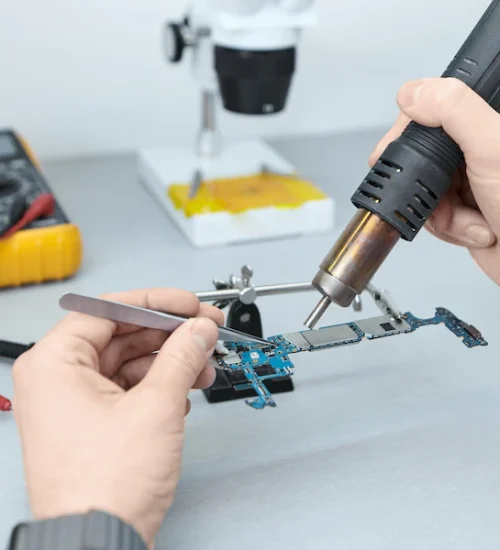 repairman-soldering-components-motherboard-while-fixing-damaged-smart-phone-using-tweezers-iron_343059-504